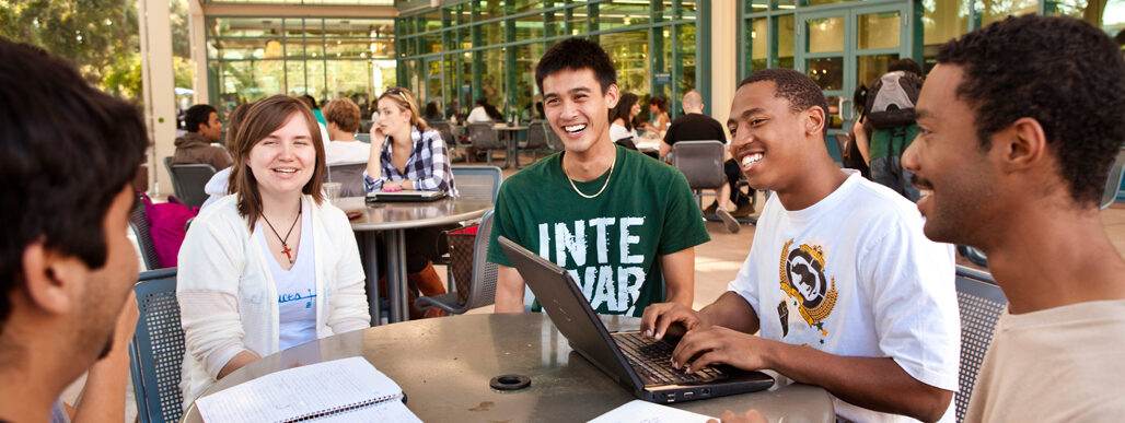 Diverse group of students laughing during a meeting outside