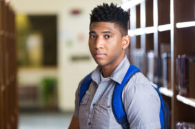 African American high school student standing in library