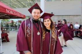 Graduates at Norco College wearing burgundy cap and gown