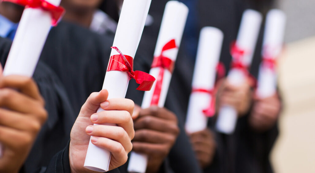 Group of multiracial graduates holding diploma