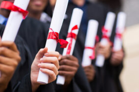 Group of multiracial graduates holding diploma