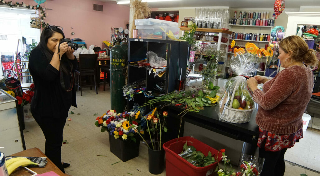 Student photographer takes a photo of a florist working during the coronavirus pandemic.