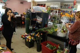 Student photographer takes a photo of a florist working during the coronavirus pandemic.
