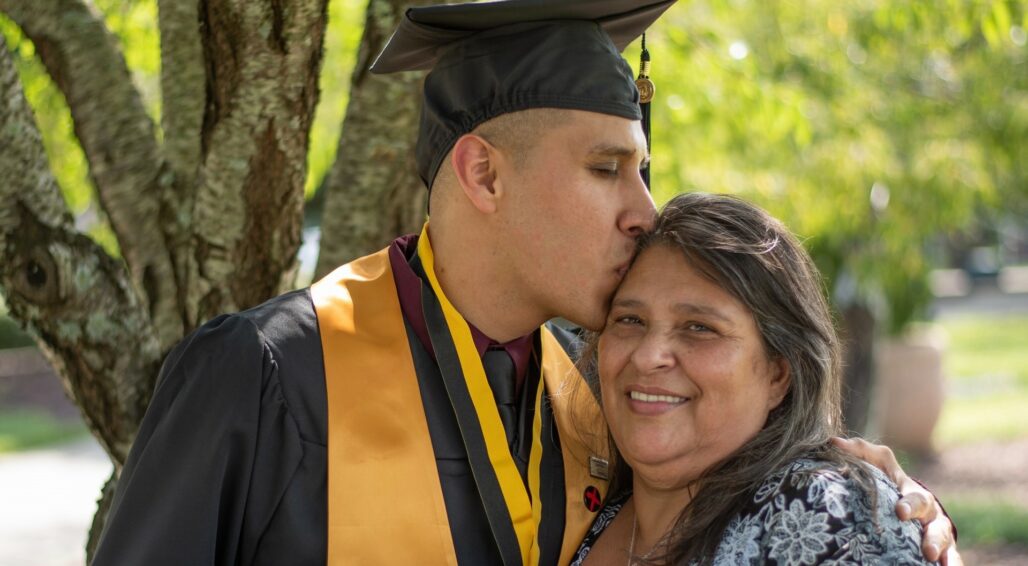 Graduate kissing his mom