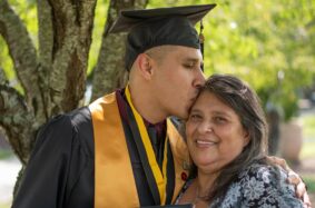 Graduate kissing his mom