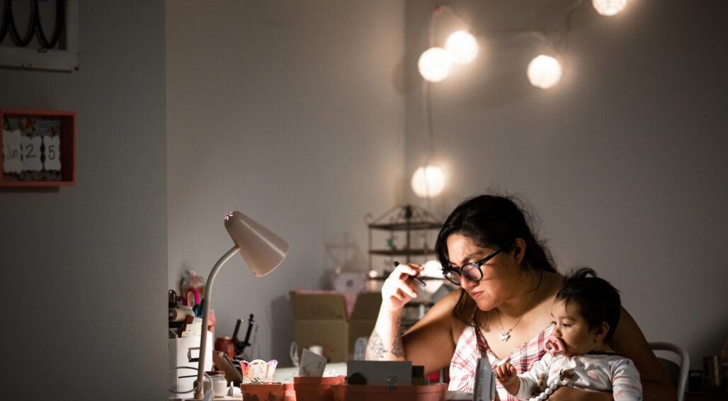 Mother Working From Home at Desk While Holding Baby Daughter