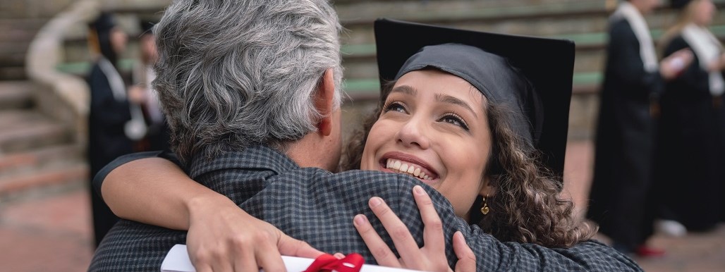 Female graduate hugging her father