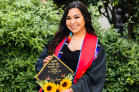 Latinx graduate posing with her cap and gown